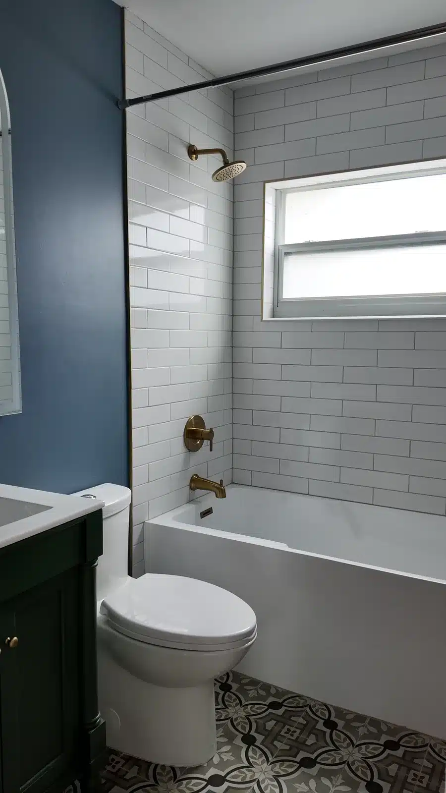 Finished New Port Richey bathroom with blue walls, a green vanity and a subway tile tub surround