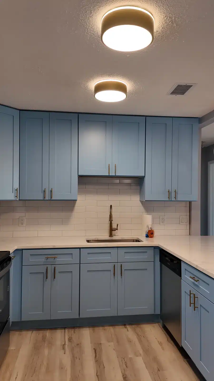 Finished New Port Richey kitchen with light blue shaker cabinets and quartz counters